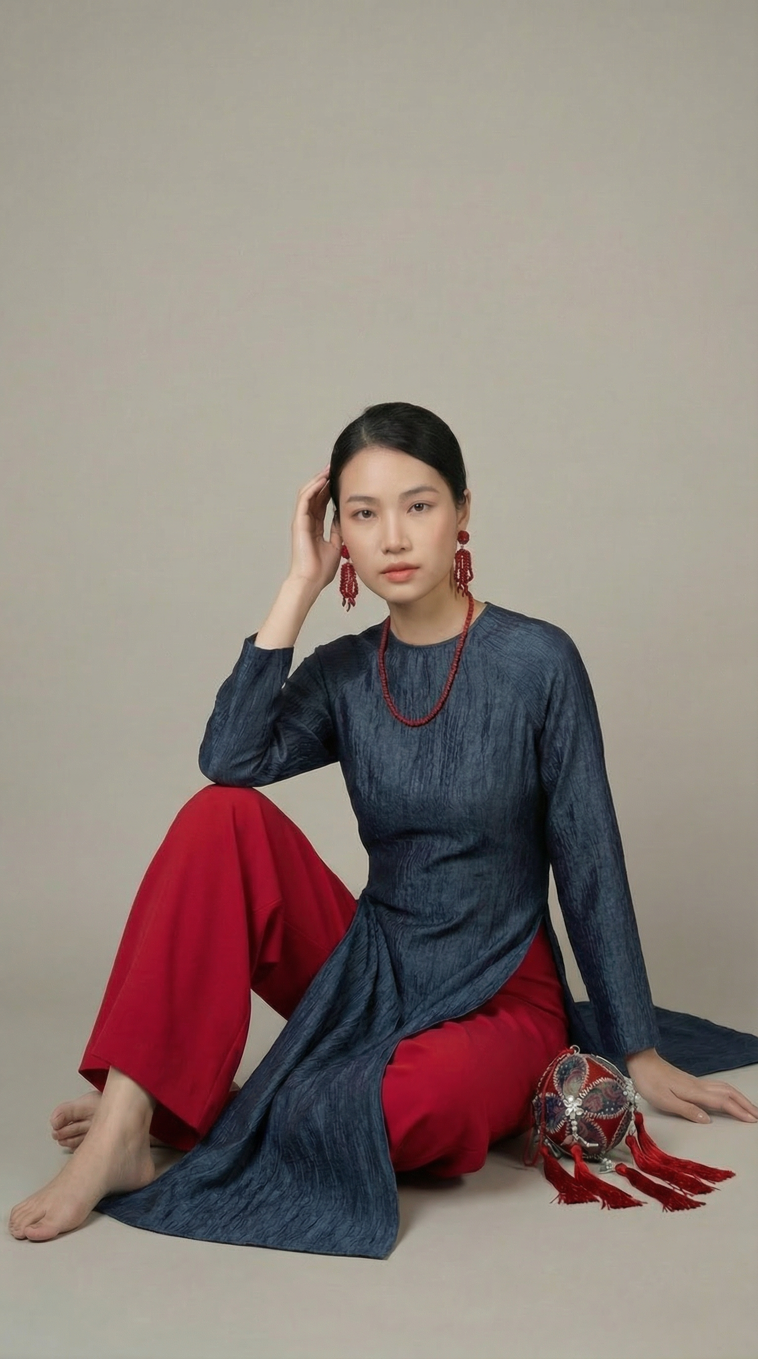 Model seated gracefully while wearing the traditional áo dài